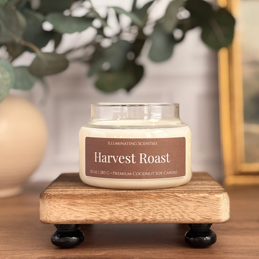 Harvest Roast jar candle by Illuminating Scentses with the lid removed, displayed on a wooden stand.